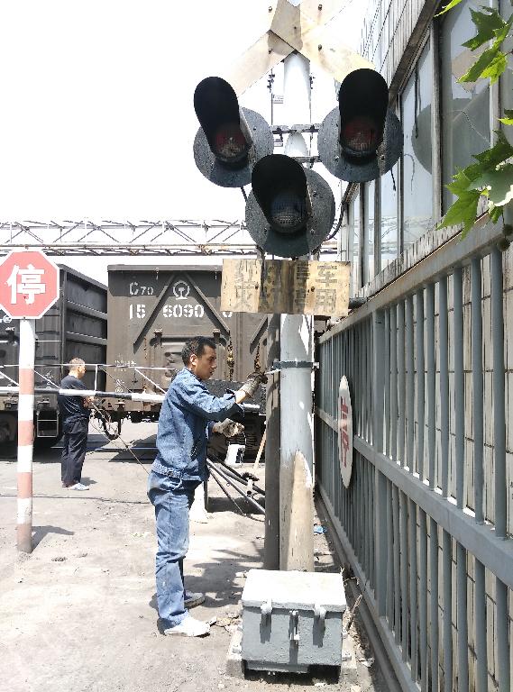 鐵運(yùn)職工對渭河電廠道口信號報(bào)警器刷漆