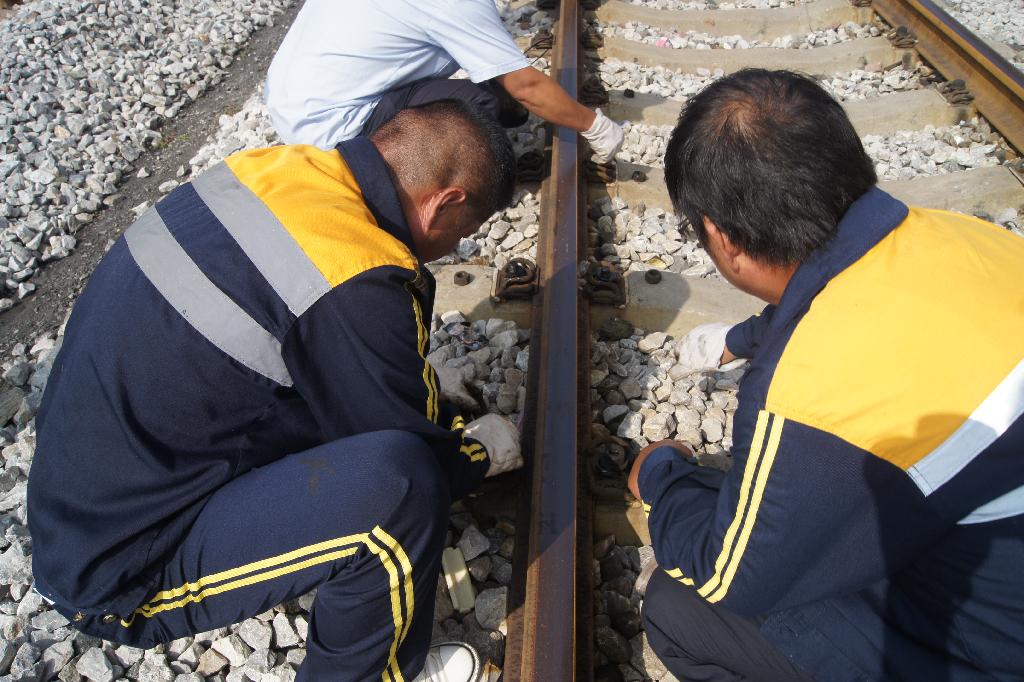 鐵路職工在仔細檢查鋼軌 鐵路職工在仔細檢查鋼軌